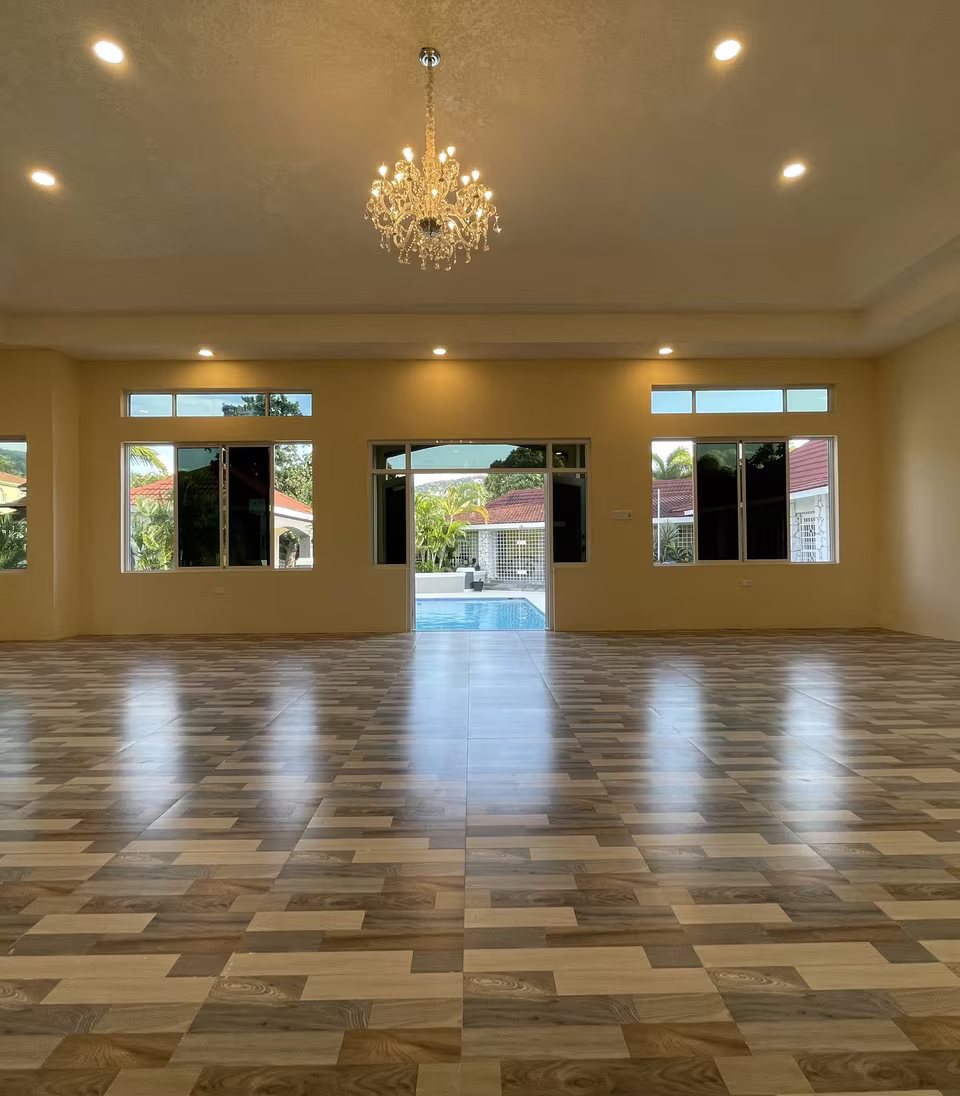 The air-conditioned ballroom, chandelier lit, with doors onto the pool deck