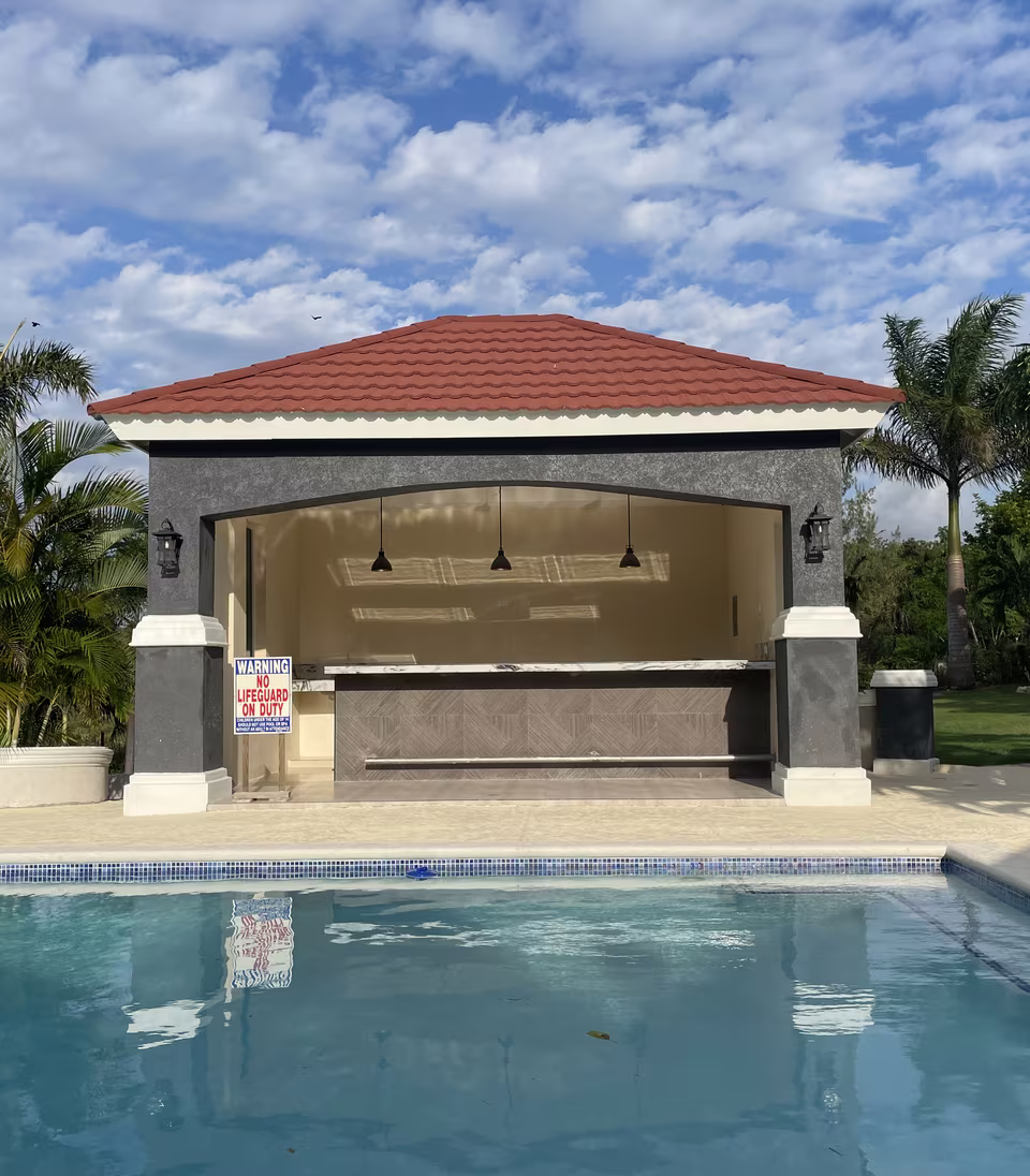 The covered poolside bar with counter seating at the water's edge